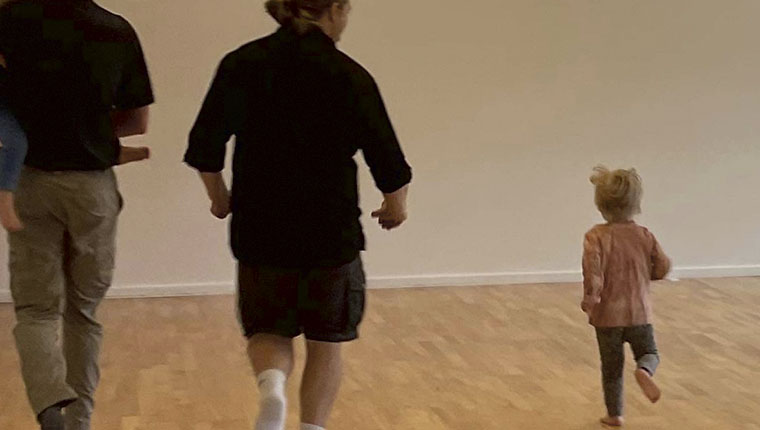 Forældre og barn løber i gymnastiksal